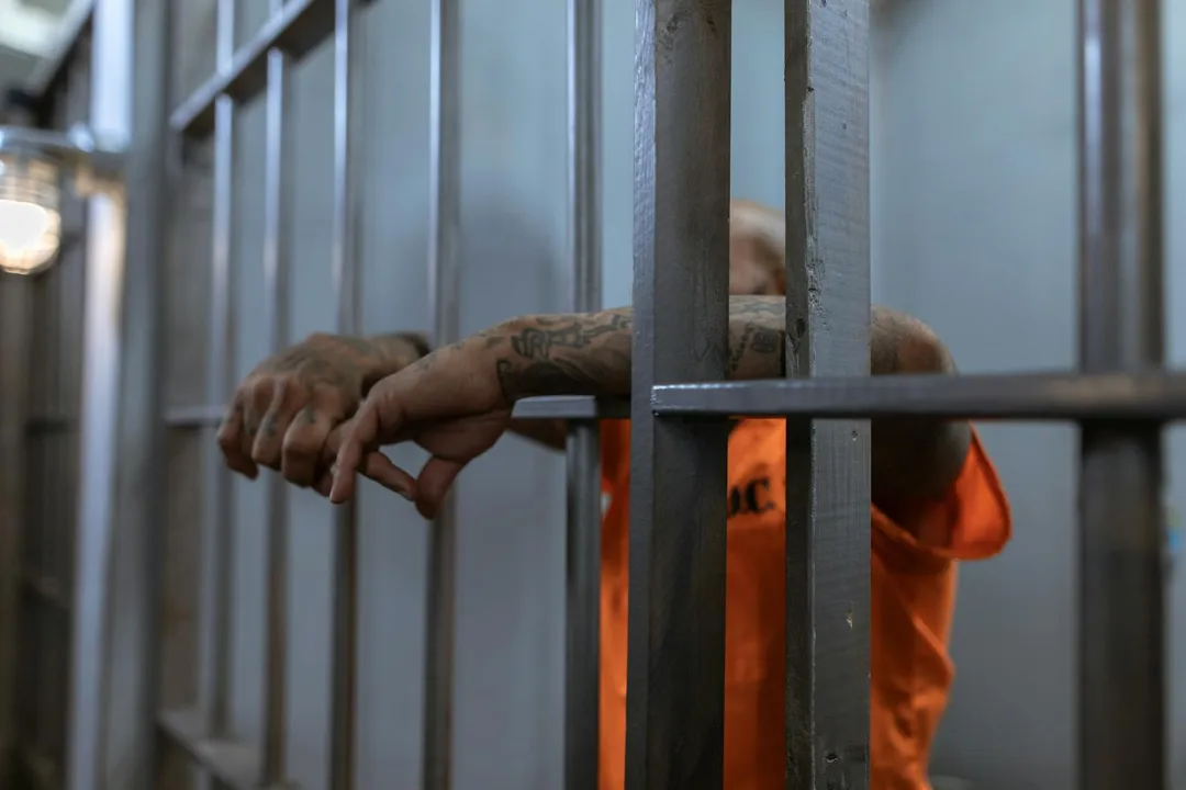 man arms outside prison cell criminal defense legal attorney in louisiana